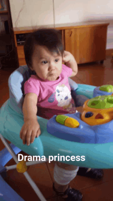 a baby is sitting in a walker with the words drama princess below it