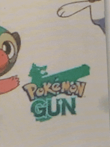 a close up of a pokemon gun logo with a cartoon character in the background