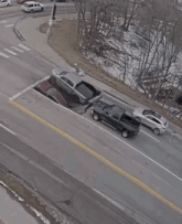 several cars are parked on the side of the road including a black truck