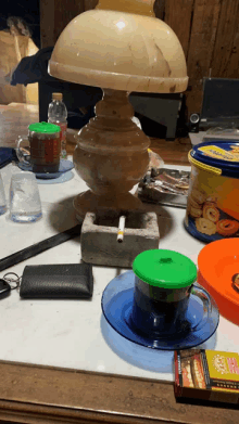 an ashtray with a cigarette in it sits on a table next to a cup of coffee