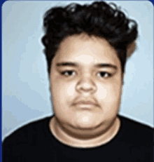 a young man with curly hair wearing a black shirt