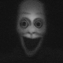 a black and white photo of a creepy face with big eyes and a big smile .