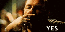 a man is smoking a cigar and the word yes is visible in the background .