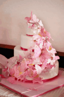 a three tiered cake with pink butterflies on it