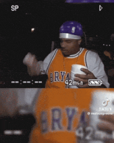 a man wearing a brya jersey holds a cup
