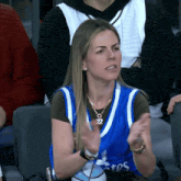 a woman wearing a blue jersey that says ' eros ' on it