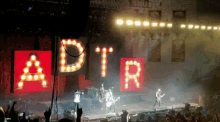 a group of people playing instruments in front of a sign that says a / d / t / r