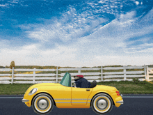 a yellow toy car is driving down a road