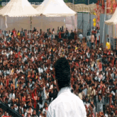 a man in a white shirt stands in front of a crowd of people with a watermark that says ' spanda230 '