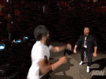 two men are dancing on stage in front of a crowd .