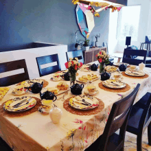 a table set for a tea party with a floral table cloth