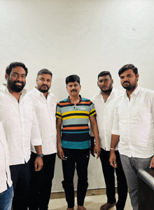 a group of men posing for a picture one of them wearing a puma shirt