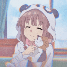 a girl wearing a panda hoodie holds a cat