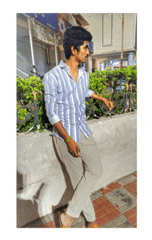 a man in a striped shirt is standing in front of a building that says ' hdfc ' on it