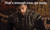 a man with a beard is sitting on a couch with the words that 's enough now go away