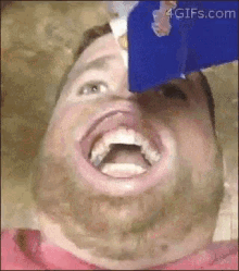 a close up of a man 's face with a bottle of ice cream coming out of his mouth .