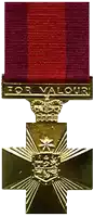 a gold medal with a red ribbon that says " for valour "