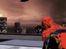 a spider man is standing in front of a city in a video game and looking out a window .