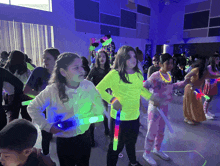 a group of young girls are dancing in a dark room