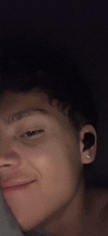 a close up of a person 's face wearing earbuds