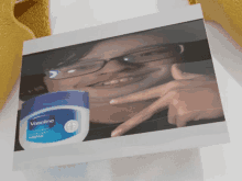 a picture of a person with glasses and a jar of vaseline