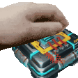 a hand is holding a box that looks like a calculator with a bunch of buttons on it .