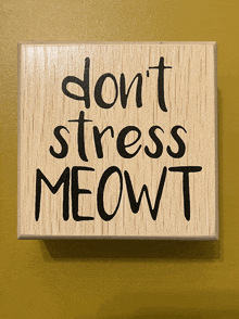 a wooden sign that says " do n't stress meowt " on it