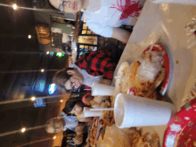 a group of people sit at a table with plates of food and drinks