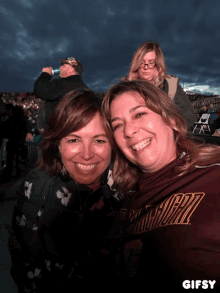 two women are posing for a picture and one is wearing a shirt that says ' virginia tech ' on it