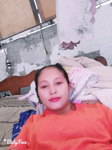 a woman in an orange shirt is laying on a bed with the words buty face at the bottom