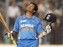 a man in a blue sahara india jersey holds his bat and helmet