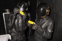 a man in a helmet holds a corn on the cob