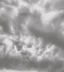 a black and white photo of a cloudy sky with a lot of clouds in it .