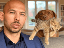 a man in a suit holds a cat and a dog in his lap