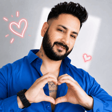 a man in a blue shirt is making a heart with his hands