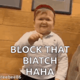 a little boy is holding a lollipop and saying `` block that biatch hahaha '' .