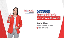 a woman in a red jacket is standing in front of a re/max logo