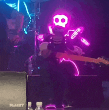 a man in a skeleton costume is playing a guitar on stage