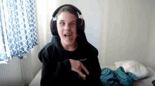 a young boy wearing headphones and a black shirt that says " i react "