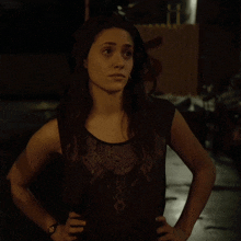 a woman with her hands on her hips is wearing a watch