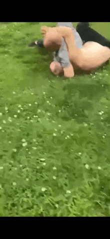 a man is laying on his back in the grass in a field .