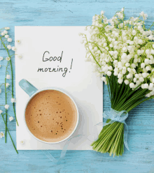 a bouquet of lily of the valley flowers sits next to a cup of coffee and a note that says good morning