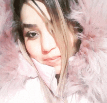 a close up of a woman wearing a pink fur hooded jacket