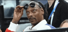 snoop dogg is wearing sunglasses and says bru in the corner