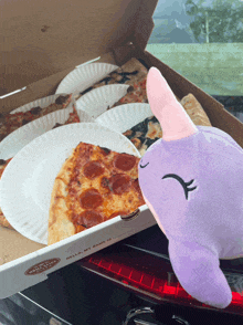 a purple stuffed animal is sitting next to a pizza box that says hello my name is