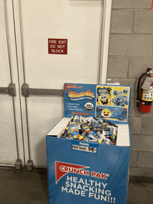 a box of crunch pak healthy snacking made fun sits in front of a fire exit