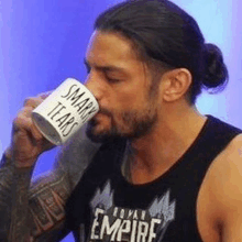 roman reigns is drinking from a coffee mug that says smart tears .