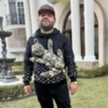 a man is standing in front of a building holding a statue of a dog .