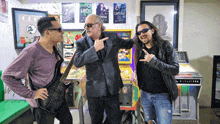 three men are posing in front of a pinball machine that says wulfizer