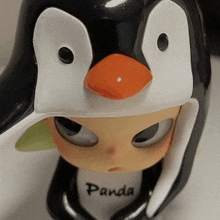 a close up of a penguin figurine with the word panda on its chest